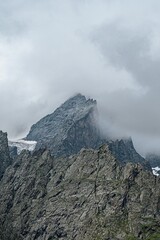 Clouds envelop the dramatic mountain peaks of North Ossetia, creating an enchanting landscape that captivates nature lovers and adventurers. This serene setting invites exploration and awe