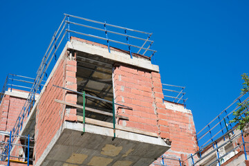 Obraz premium Modern brick building construction against clear blue sky in urban development