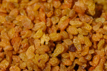 Golden raisins glistening in sunlight, showcasing natural sweetness and vibrant color in a rustic kitchen setting