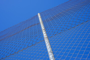 Chain link fence against clear blue sky: modern security and boundary concept