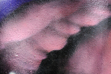 Fototapeta premium Textured abstract art with pink and purple spray paint detail on urban wall