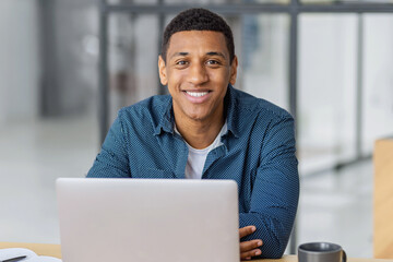 Smiling african american man working on laptop
