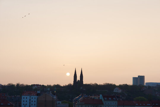 Morning sun rising among two church towers. Beautiful cozy sunrise over the city.