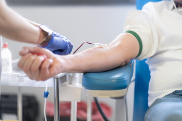 The hands of an anonymous nurse work to ensure the blood catheter starts flowing for the patient....
