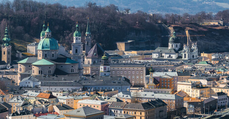 Aerial view of Salzburg, Austria, featuring the Salzburg Cathedral with green domes, pastel colored...