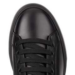 Close up top view of black leather sneaker with black laces on white background.