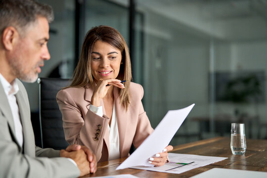 Legal consultancy concept. Business woman lawyer attorney showing document to man client providing advisory services, professionals discussing tax papers working in office at meeting.