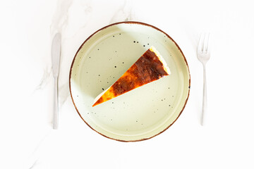 Slice of cheesecake served on a plate with a knife and fork