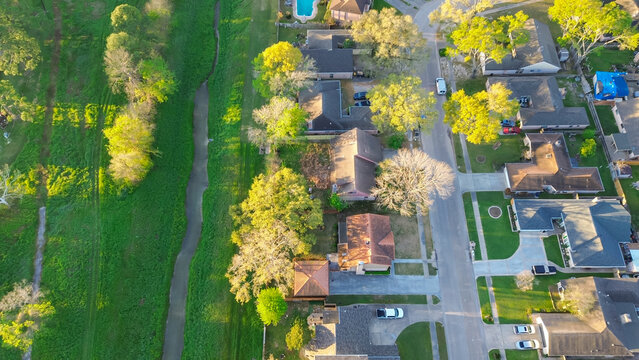 Vacant land and grass lined drainage channel near residential neighborhood suburban houses in Harris County, Houston, natural streams and manmade systems carrying stormwater runoff from rainfall