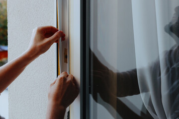 A young man has his window frame insulated.