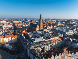 Aerial image of Wroclaw, Poland, featuring St. Elizabeth's Church, red roofed buildings, colorful townhouses, and a mix of modern and traditional architecture.