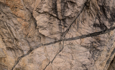Closeup of Rugged Outdoor Rock Wall Showing Natural Cracks and Weathering