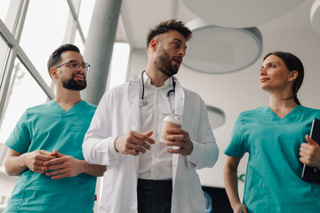 Obraz premium Medical team walking and talking in hospital corridor