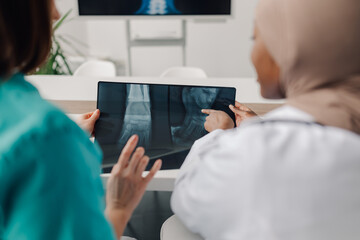 Doctors examining foot and ankle x ray on digital tablet in hospital