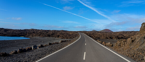 Paved road without anyone in hostile environment of black volcanic rocks. Paved road without anyone in hostile environment of black volcanic rocks on the island of Lanzarote, Canary archipelago, Spain