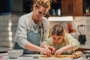 Mother and daughter baking together in kitchen