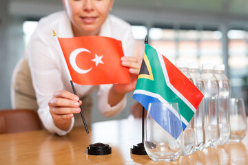 Little flag of South Africa on table with bottles of water and flag of Turkey put next to it by...