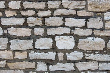 Light colored stone wall with dark black mortar