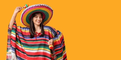 Young woman in sombrero and poncho playing maracas on yellow background with space for text