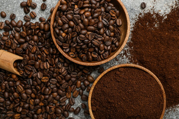 Bowls with coffee beans and powder on grey background