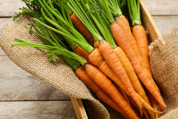 Tasty fresh carrots on wooden background