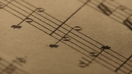 Slider macro footage of Mozart aged book with music notes sheet. Archival manuscripts, vintage musical score for piano. Educational symbols for musician