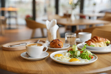 Delicious breakfast served on wooden table in cafe