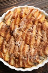 Delicious bread pudding with raisins and cinnamon on wooden table, top view