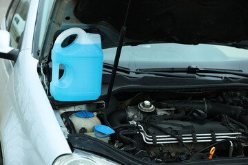 Antifreeze in plastic canister under hood of car