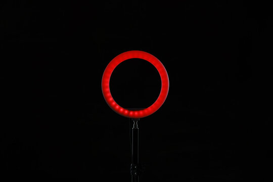 Ring lamp on stand against black background