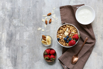 Napkin, bowl with tasty granola, nuts and berries on grunge background