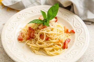White plate with tasty pasta carbonara and napkin on table, closeup