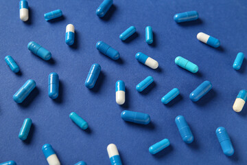 Different pills on blue background, closeup