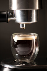 Espresso Shot Dripping into Glass Cup from Coffee Machine