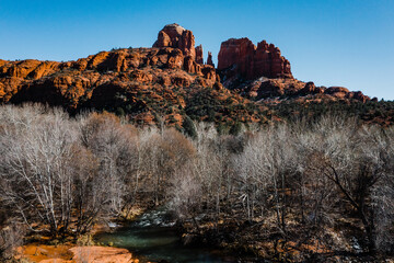 light hitting the red rocks of arizona with creek in foreground