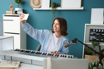 Young woman with synthesizer recording podcast in studio