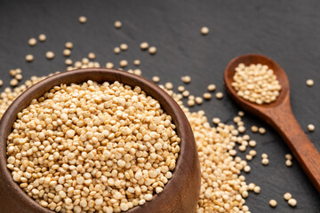 Organic white quinoa seeds in a spoon and bowl - Chenopodium quinoa