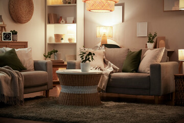 Interior of living room with sofas, coffee table and glowing lamps