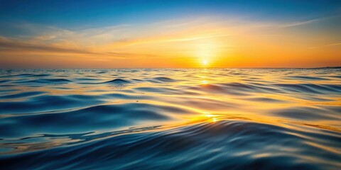 Obraz premium Golden Sunset Hues Reflecting on Gentle Ocean Waves at the Horizon