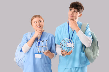 Thoughtful medical students with molecular models on light background