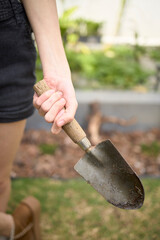 Close-up of a hand holding a gardening trowel