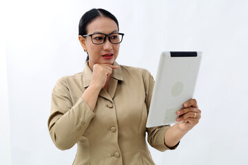 Portrait of asian civil servant woman looking at digital tablet with thinking gesture, side view....