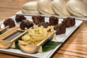 Short rib, pieces of roasted beef rib accompanied by French fries, vegetables, soy sauce and buns, beef