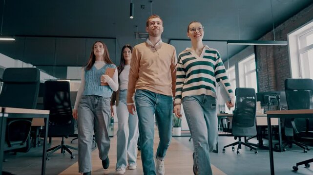 Business team in a modern open space startup office walking together. Diverse group of businesspeople smiling while having a discussion. Successful mixed race colleagues collaborating on a new project
