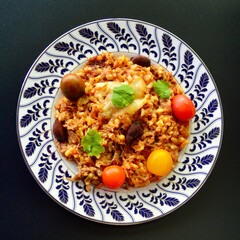 Beef and black olive risotto with tomatoes cheese and parsley. 