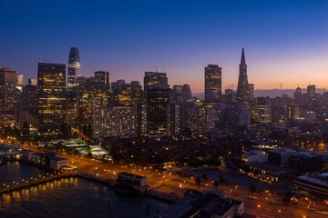 Obraz premium Aerial view of the San Francisco skyline at dusk in California, USA. The city lights illuminate the buildings and streets below. The photo captures the beauty of the city.