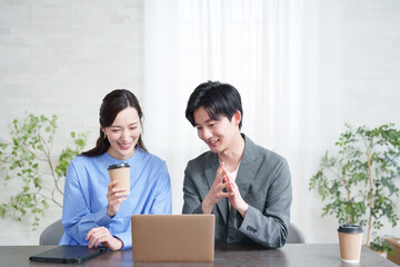 パソコンを見て打合せするビジネスマン男女