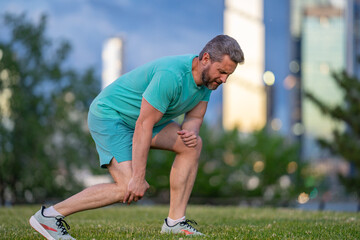 Knee after sport. Athletic man suffering from knee pain. Injured man holding leg. Pain after...