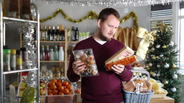 Man with soft nutty nougat and sweet traditional Catalan desserts panellets in a Christmas supermarket. Buyer chooses European sweets for the New Year. High quality 4k footage