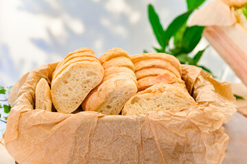 Rustic Bread Slices in Paper Lined Basket. Close-up of freshly sliced rustic bread served in a paper-lined basket, perfect for buffets, breakfasts, or catering events.